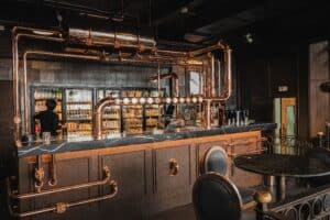 Craft beer bar counter with copper pipes and beverage refrigerators at Davin Cafe