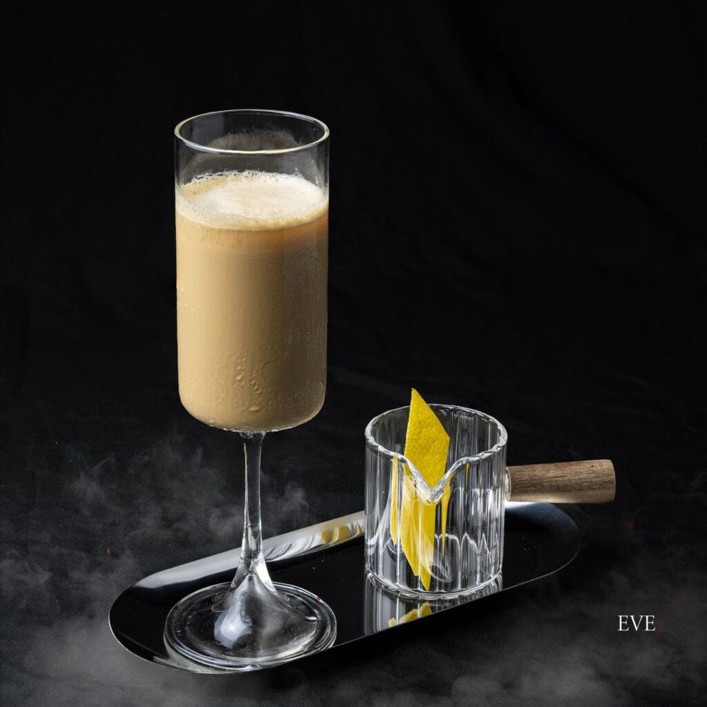 เครื่องดื่ม Eve กาแฟซิกเนเจอร์ของ Davin Cafe เสิร์ฟพร้อมเครื่องเคียงในแก้วเล็กบนถาดสีเงิน.