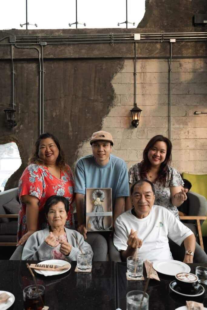 ภาพถ่ายครอบครัวที่มีความสุข กำลังฉลองโอกาสพิเศษพร้อมของขวัญภายในร้าน Davin Cafe.