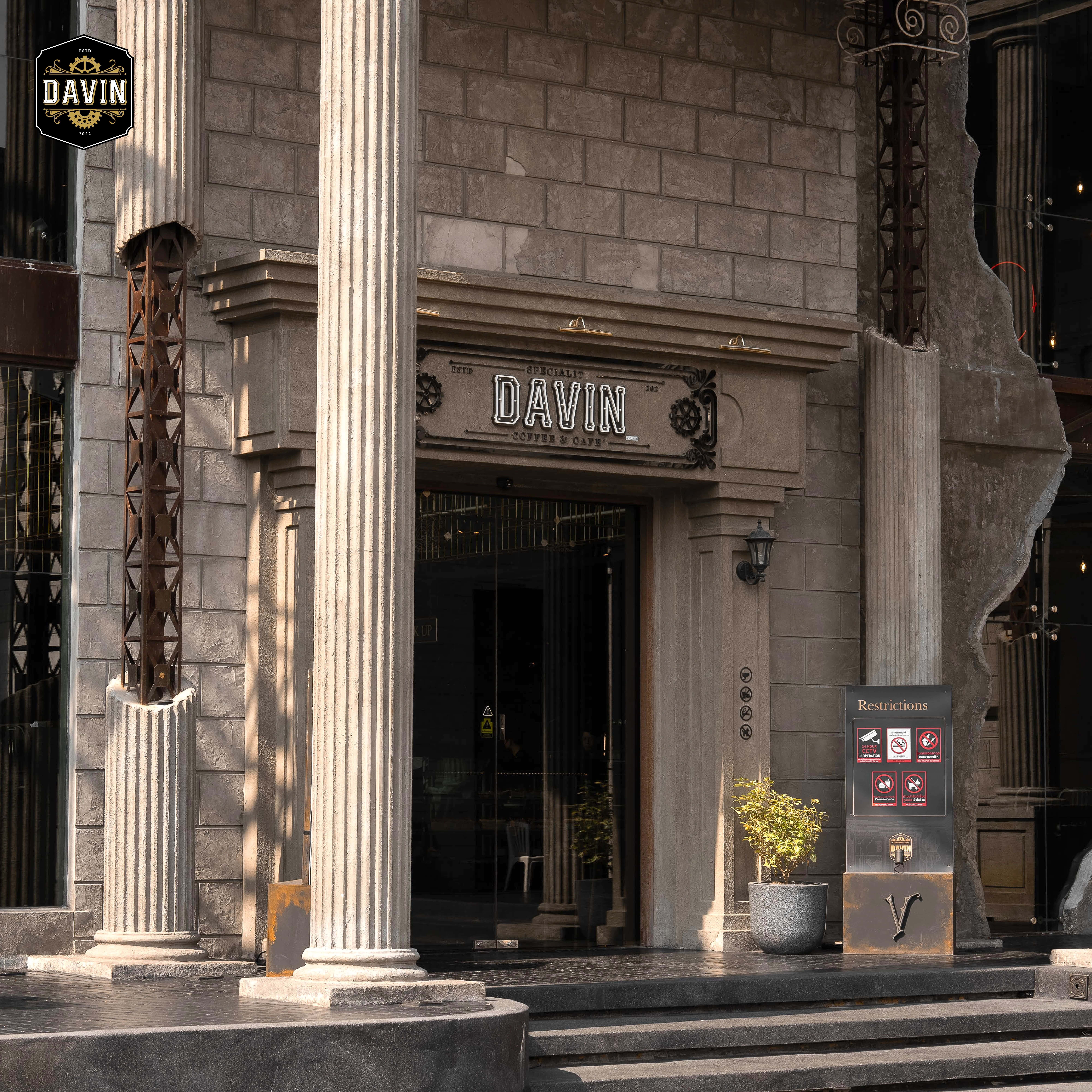 The main entrance of Davin Cafe with its rustic classical facade, featuring prominent columns and signage.