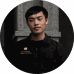 A professional portrait of a male staff member from Davin Cafe wearing a black uniform.