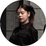 A professional portrait of a female staff member from Davin Cafe in a black uniform with a bow in her hair.