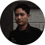 Headshot of a male Davin Cafe employee wearing a black uniform, with a confident expression against a concrete wall.