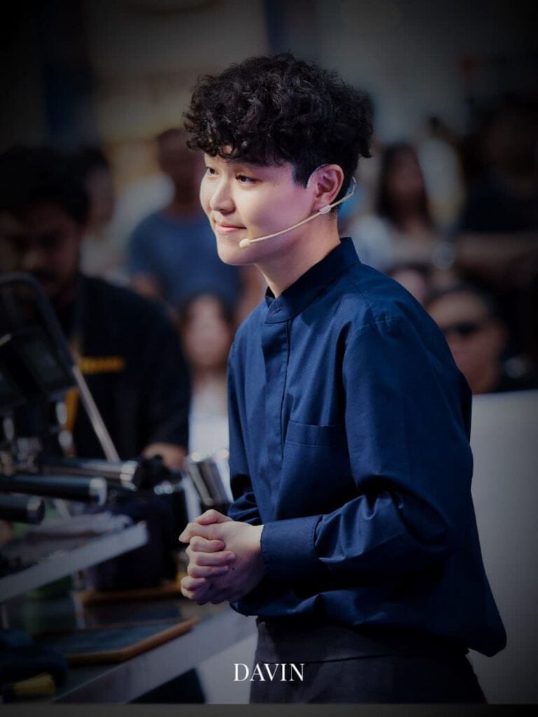 ภาพถ่ายบุคคลของ เจน-กวินนาร์ท แชมป์บาริสต้าประเทศไทย ขณะกำลังยิ้มในงานอีเวนต์.