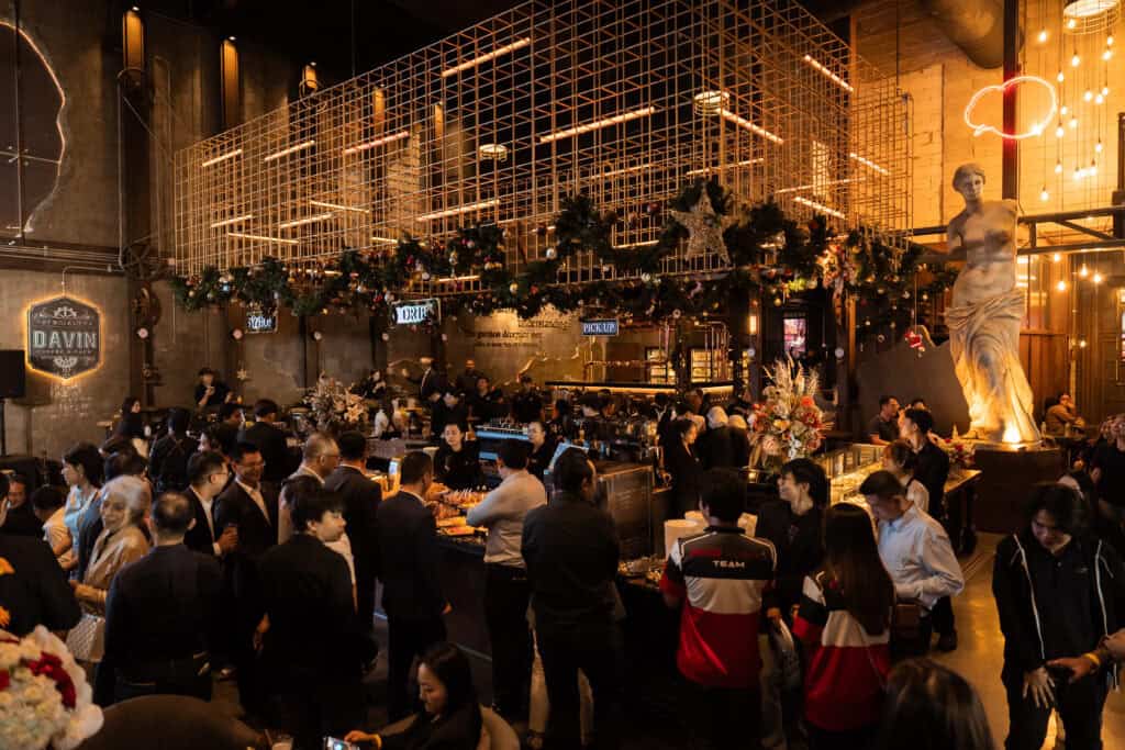 A lively corporate New Year celebration hosted at a restaurant catering venue in Bangkok, featuring organized food stations, drinks, and professional event service