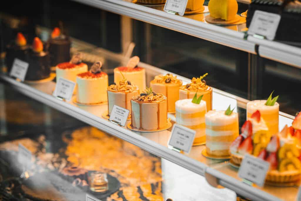 Premium bakery cakes beautifully displayed in a glass showcase, offering a wide variety of desserts for selection