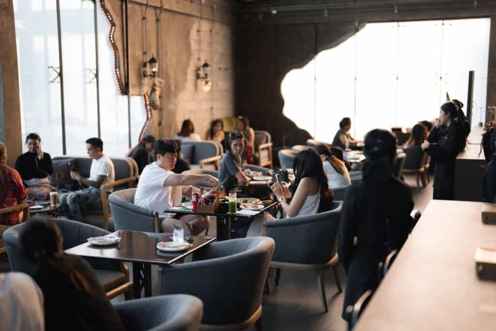 บรรยากาศแขกองค์กรนั่งรับประทานอาหารและพูดคุยภายในสถานที่จัดงานเลี้ยงบริษัท พื้นที่นั่งถูกออกแบบให้รองรับการสังสรรค์และการใช้งานจริงของงานบริษัท