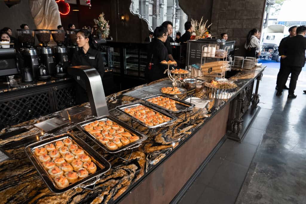 A food and beverage service station staffed by professionals inside a corporate event venue, supporting smooth service during company parties and business functions.