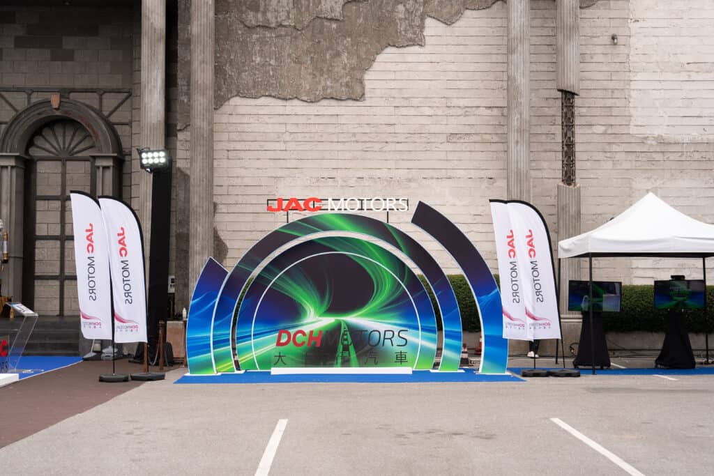 A professional event venue featuring a branded backdrop and photo spot for corporate launches, product unveilings, and business events