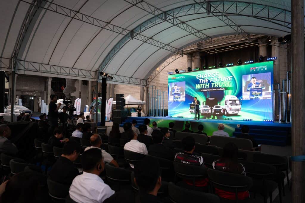 A professional event venue hosting a corporate product launch with a large LED stage, full lighting and sound system, and a live audience