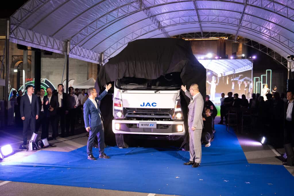 A professional event venue hosting an official product launch ceremony with a reveal stage, lighting system, executive guests, and full-scale event production