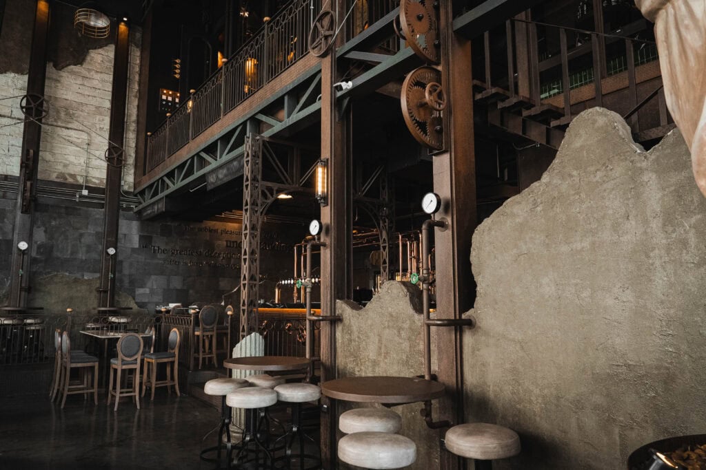 มุมที่นั่งภายในคาเฟ่รามอินทรา โถงสูงตกแต่งสไตล์อินดัสเทรียลลอฟต์ ใช้โครงเหล็กและดีไซน์เครื่องกล สร้างบรรยากาศสงบ เป็นส่วนตัว เหมาะสำหรับนั่งคุยและใช้เวลาใน Davin Cafe