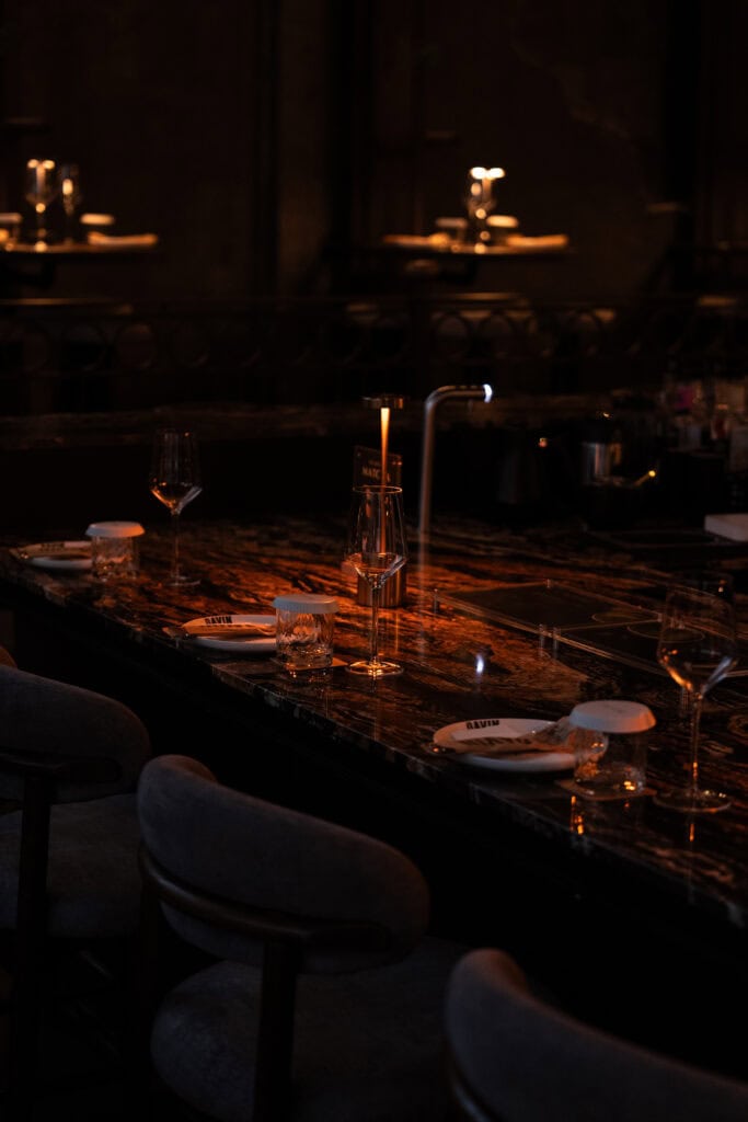 An intimate dinner bar counter at Davin Cafe, featuring warm ambient lighting and elegant table settings, ideal for a refined evening dinner experience in a romantic, upscale atmosphere.