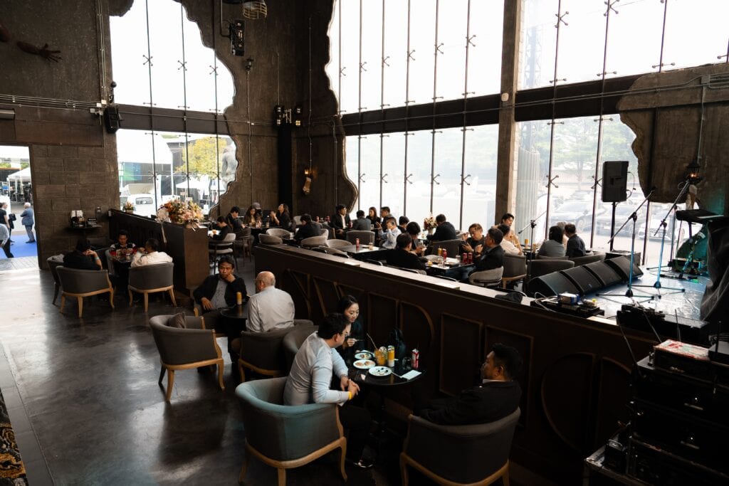 An open-space seminar venue at Davin Cafe in Ramintra, hosting a corporate-style gathering with flexible seating and natural light, offering a modern alternative to traditional meeting rooms for seminars and workshops.