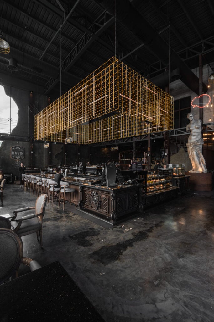 A photogenic cafe interior with industrial luxury design, high ceilings, and architectural details, perfect for wide-angle photography and lifestyle content creation