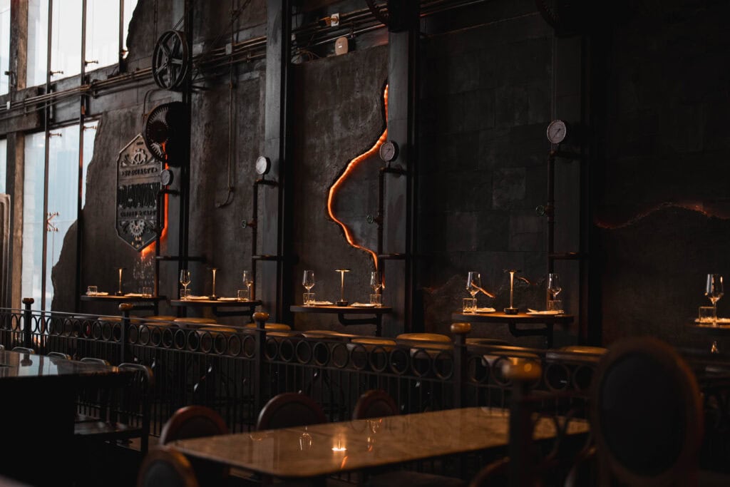 An intimate private dining corner inside Davin Cafe, featuring softly lit tables and an industrial-elegant interior, designed for a romantic dinner experience that emphasizes privacy, atmosphere, and refined evening dining.