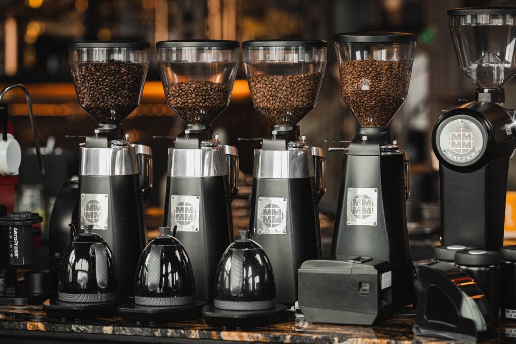 A lineup of professional coffee grinders showcasing carefully separated specialty coffee beans, highlighting precision, single-origin selection, and quality-focused coffee preparation.