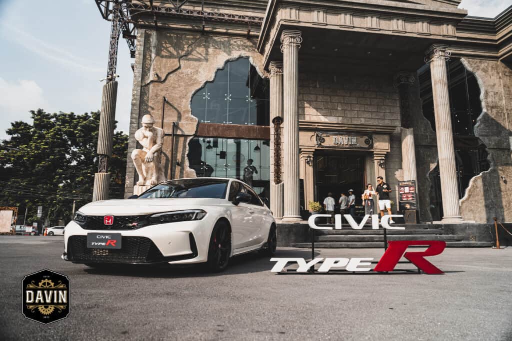An outdoor automotive product display set in front of Davin Cafe, where a performance car is showcased against a striking architectural backdrop, creating a premium brand exhibition experience that enhances visibility and brand perception