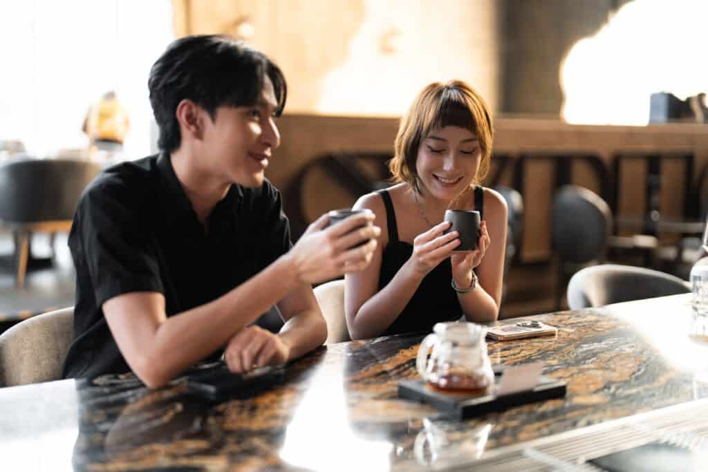 A young couple enjoying coffee together in a warm and relaxed cafe setting, an ideal casual atmosphere for a comfortable first date conversation
