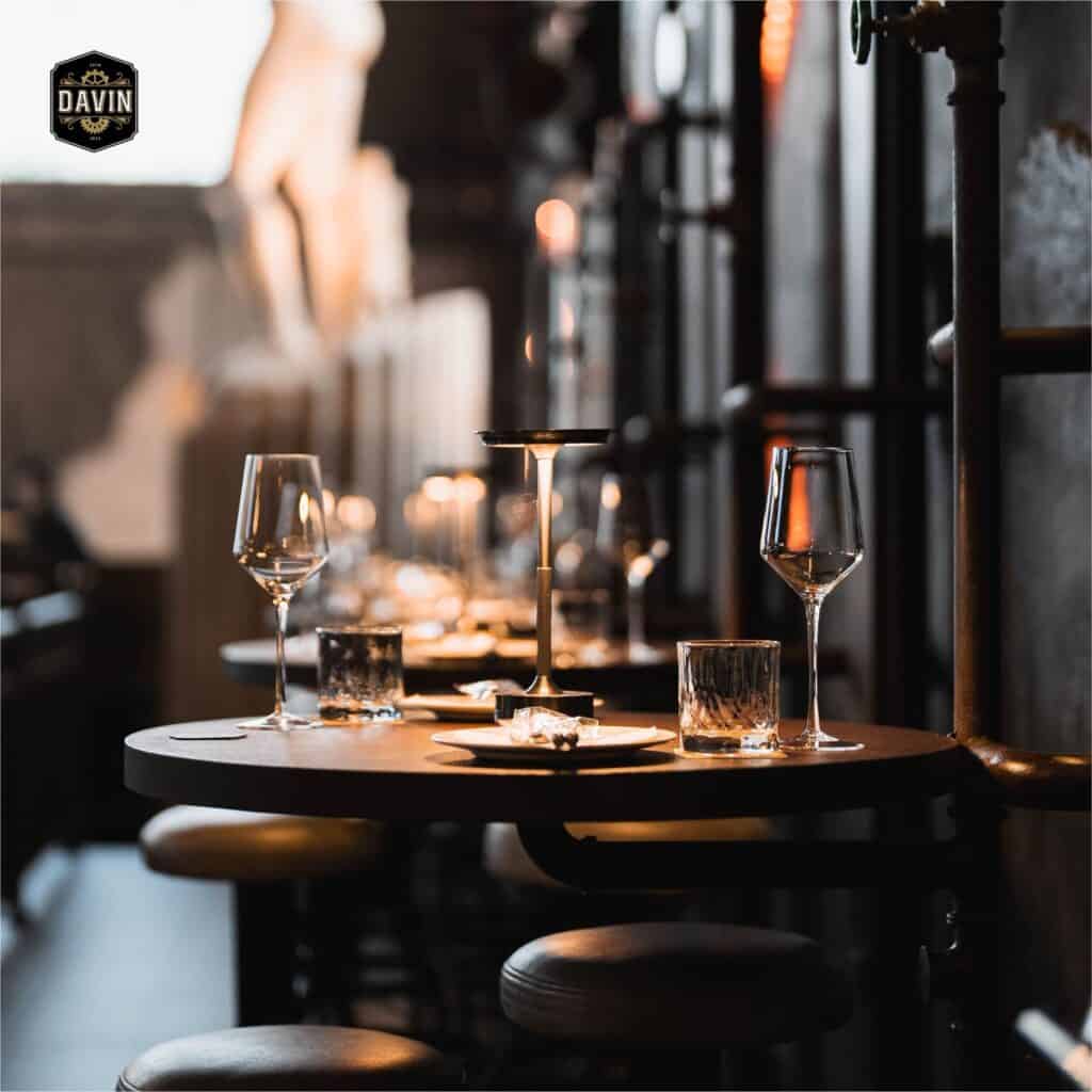 โต๊ะอาหารไฟสลัวพร้อมแก้วไวน์และเทียนบนโต๊ะ จัดเตรียมสำหรับเดตแรกในบรรยากาศโรแมนติกที่อบอุ่นและเป็นส่วนตัว