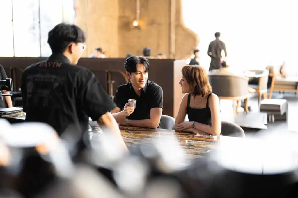 A young couple having a natural conversation during their first date inside a warm and stylish cafe, creating a relaxed and memorable first impression