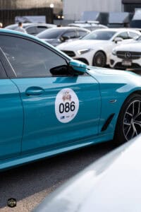 รถยนต์สีฟ้าสำหรับกิจกรรมงานอีเวนต์ที่จอดในลานจอดรถพร้อมป้ายหมายเลข 086.