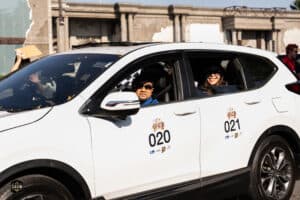 รถยนต์ไฟฟ้าสีขาวพร้อมผู้โดยสารในงานอีเวนต์ เที่ยวสุดโลก 2025 ที่ Davin Cafe.