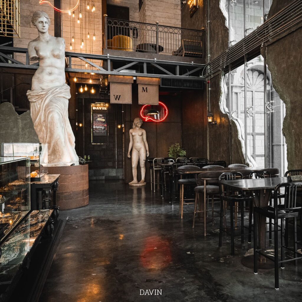Coffee shop Bangkok artistic interior at Davin Cafe featuring classical statues and industrial design aesthetic cozy seating and photogenic cafe ambience in Bangkok