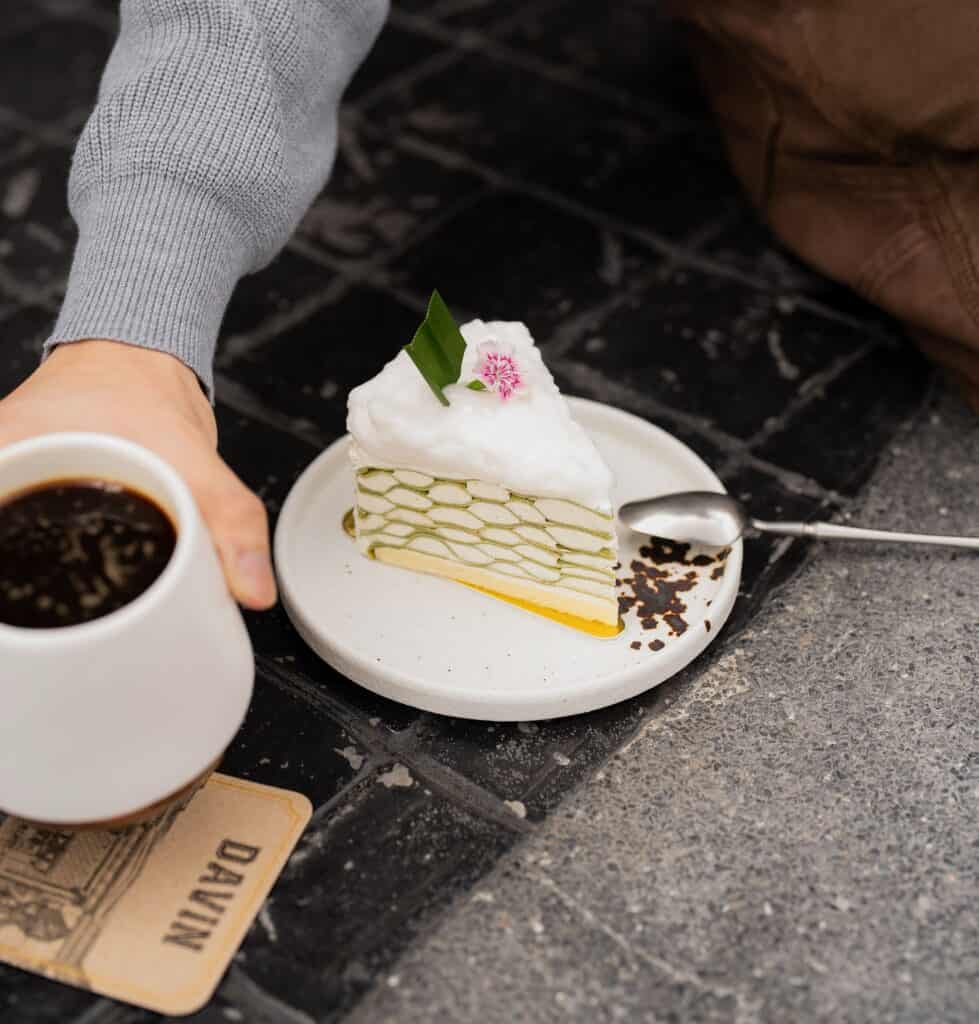 Delicious cake cafe Coconut Pandan Crepe Cake layered pandan and coconut crepe dessert served with coffee at a premium dessert cafe