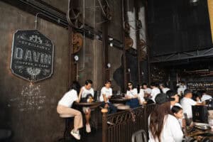 ดินเนอร์ในบรรยากาศเท่ที่ Davin Cafe พร้อมลูกค้าเพลิดเพลินในร้านกาแฟสไตล์อุตสาหกรรม.