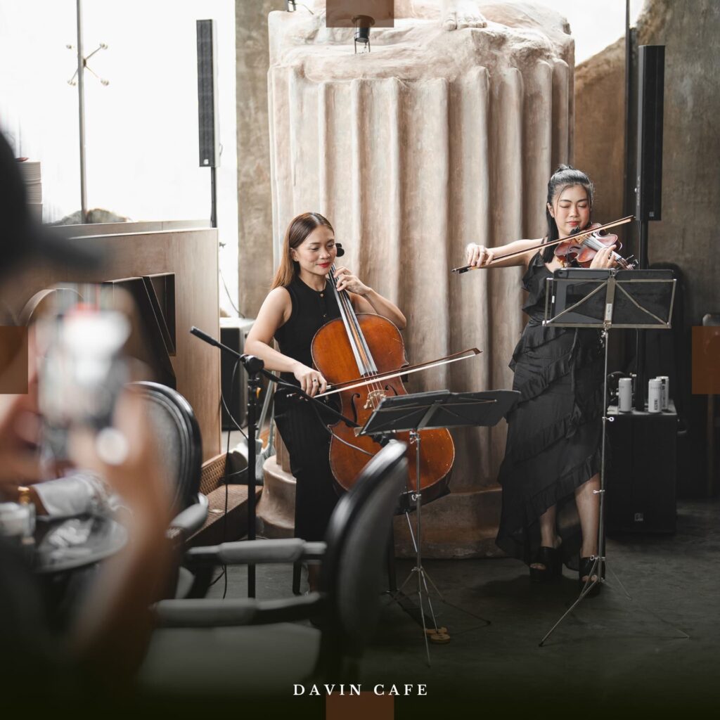 บรรยากาศการแสดงดนตรีสดที่ Davin Cafe โดยสองนักดนตรีหญิงเล่นเชลโล่และไวโอลิน สร้างบรรยากาศผ่อนคลายภายในร้านอาหารที่ตกแต่งสไตล์โมเดิร์นลอฟท์