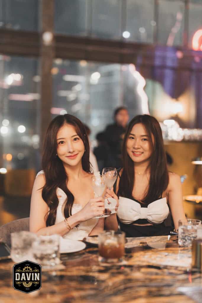 ลูกค้าสองคนนั่งดื่มและยกแก้วชนกันในบรรยากาศอบอุ่นภายใน Davin Cafe สะท้อนฟีลคาเฟ่ สไตล์ยุโรป ที่เหมาะสำหรับการสังสรรค์และใช้เวลาพิเศษกับเพื่อนในกรุงเทพ