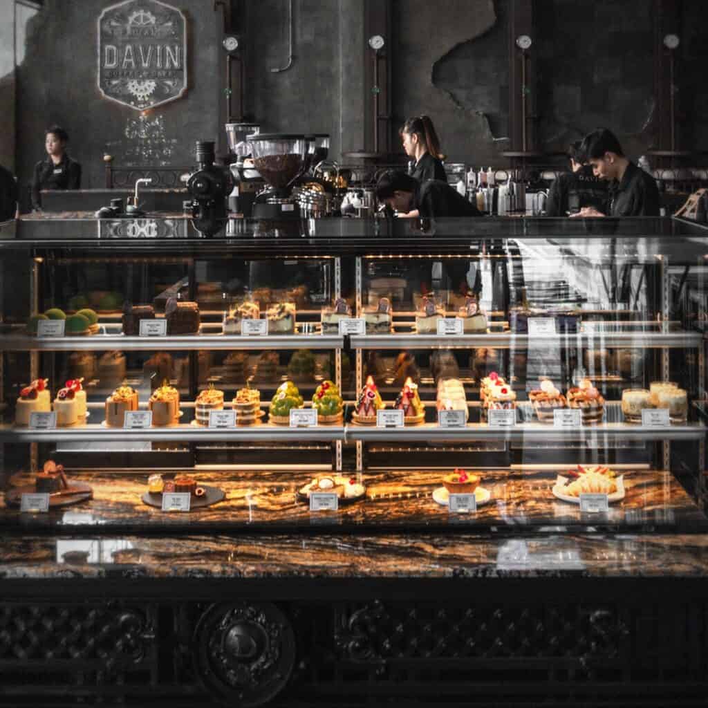 Premium dessert display at DAVIN CAFE, a popular liap duan cafe in Bangkok, featuring an elegant bakery counter with artisanal pastries and a visually appealing setup for cafe lovers and content creators