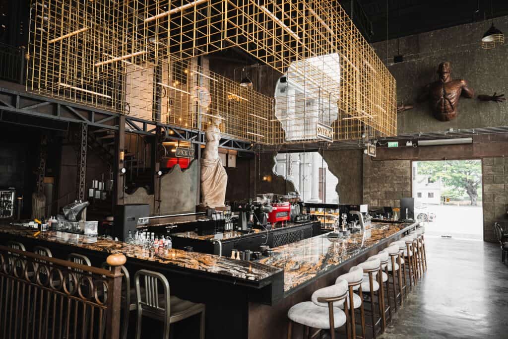 Industrial-style bar counter at DAVIN CAFE, a standout liap duan cafe in Bangkok, featuring bold architectural elements, metal framework, and a striking interior design ideal for social gatherings and visual storytelling