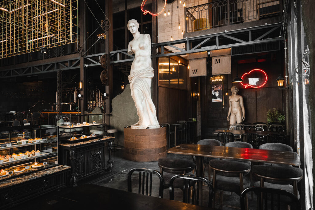 A private dining and meeting corner at Davin Cafe featuring industrial-luxury design with long tables, ideal for small group seminars, team discussions, or intimate corporate gatherings in Bangkok