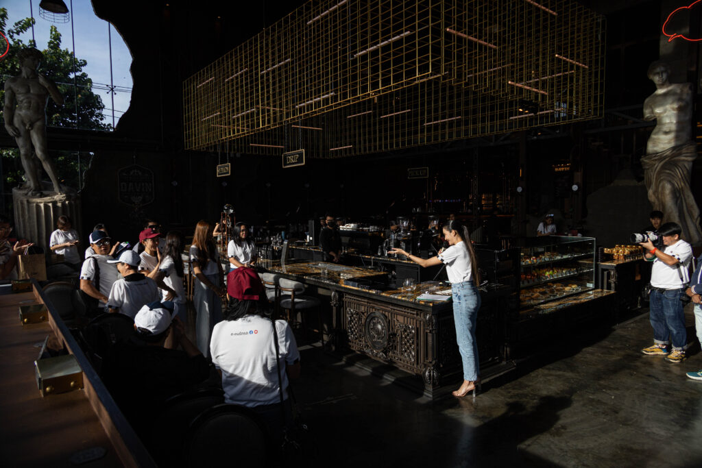 วิทยากรกำลังสาธิตการชงกาแฟต่อหน้าผู้เข้าร่วมภายใน Davin Cafe ผู้ร่วมงานยืนล้อมดูและมีส่วนร่วม สะท้อนการเป็นสถานที่จัดสัมมนา กรุงเทพ ที่รองรับกิจกรรมเวิร์กชอปแบบ interactive ได้จริง