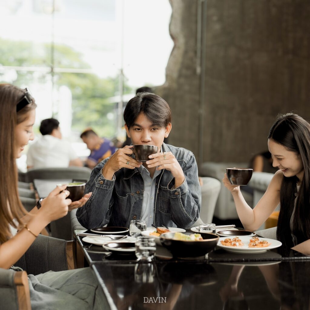 Guests enjoying coffee and shared dishes inside Davin Cafe, a Bangkok cafe and dining destination with a relaxed upscale atmosphere designed for casual gatherings, social meals, and memorable group dining experiences.