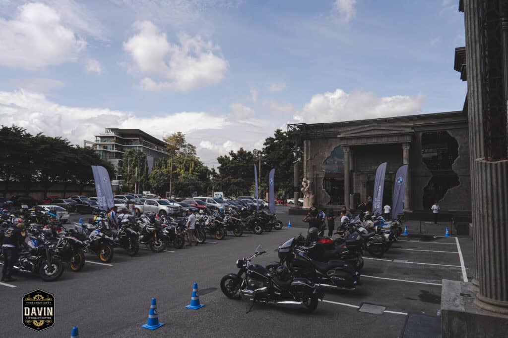 ลานกิจกรรมกลางแจ้งของ Davin Cafe ที่รองรับการรวมตัวของกลุ่ม BMW Motorrad พร้อมพื้นที่จอดรถและมอเตอร์ไซค์จำนวนมาก สะท้อนความพร้อมของสถานที่จัด Fan Meet ในกรุงเทพสำหรับงานคอมมูนิตี้ อีเวนต์แบรนด์ และกิจกรรมแฟนคลับที่ต้องการพื้นที่กว้างพร้อมบรรยากาศโดดเด่น