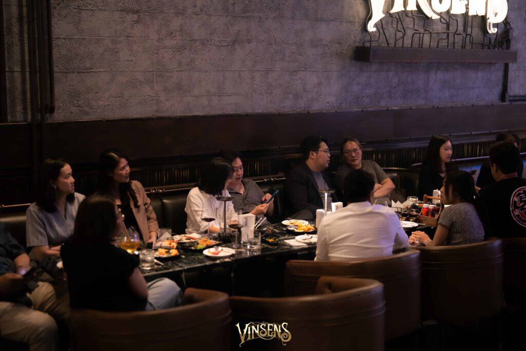 Guests gathering around a private dining table at VINSENS, showcasing a Bangkok fan meet venue with an intimate atmosphere, premium food and drink service, and flexible space for fan activities, conversations, and group event experiences.
