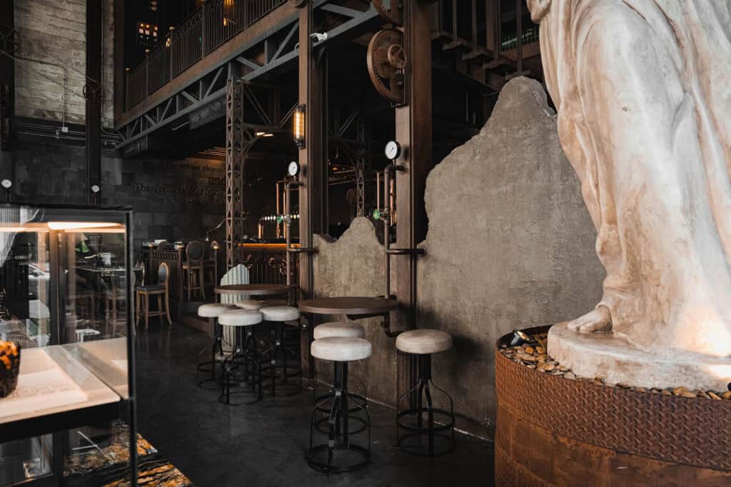 Cozy corner seating at Davin Cafe in Ramintra with high stools, a pastry display, and European-inspired interior details, ideal for guests looking for a work-friendly cafe with a quiet atmosphere and comfortable space to focus.