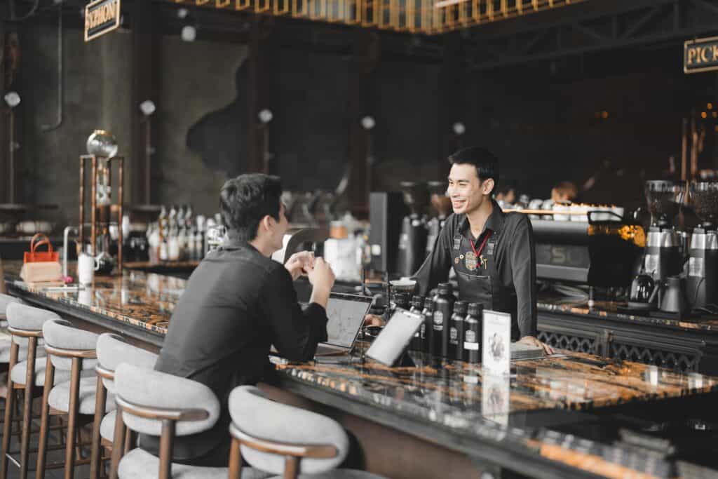 คาเฟ่ยอดฮิต รามอินทรา ที่ DAVIN CAFE ลูกค้าพูดคุยกับบาริสต้าพร้อมสัมผัสประสบการณ์กาแฟพรีเมียม บรรยากาศร้านหรู พื้นที่นั่งสบาย และบริการที่เป็นกันเอง เหมาะสำหรับคนรักคาเฟ่ในกรุงเทพ