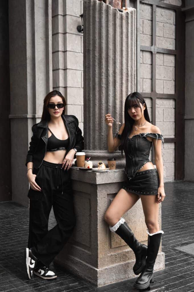 Cafe photo poses by two women in fashion looks beside a Roman-style column with coffee and desserts at DAVIN CAFE Bangkok