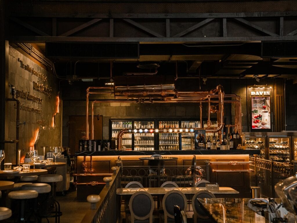 European style cafe Bangkok at DAVIN CAFE featuring an industrial loft bar interior with copper pipe details