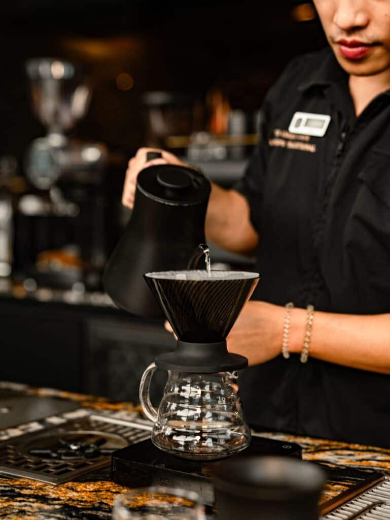 บาริสต้า DAVIN CAFE กำลังชง Panama Geisha แบบ Pour-Over ด้วยดริปเปอร์ เพื่อถ่ายทอดรายละเอียดกลิ่นและรสชาติของกาแฟ Specialty